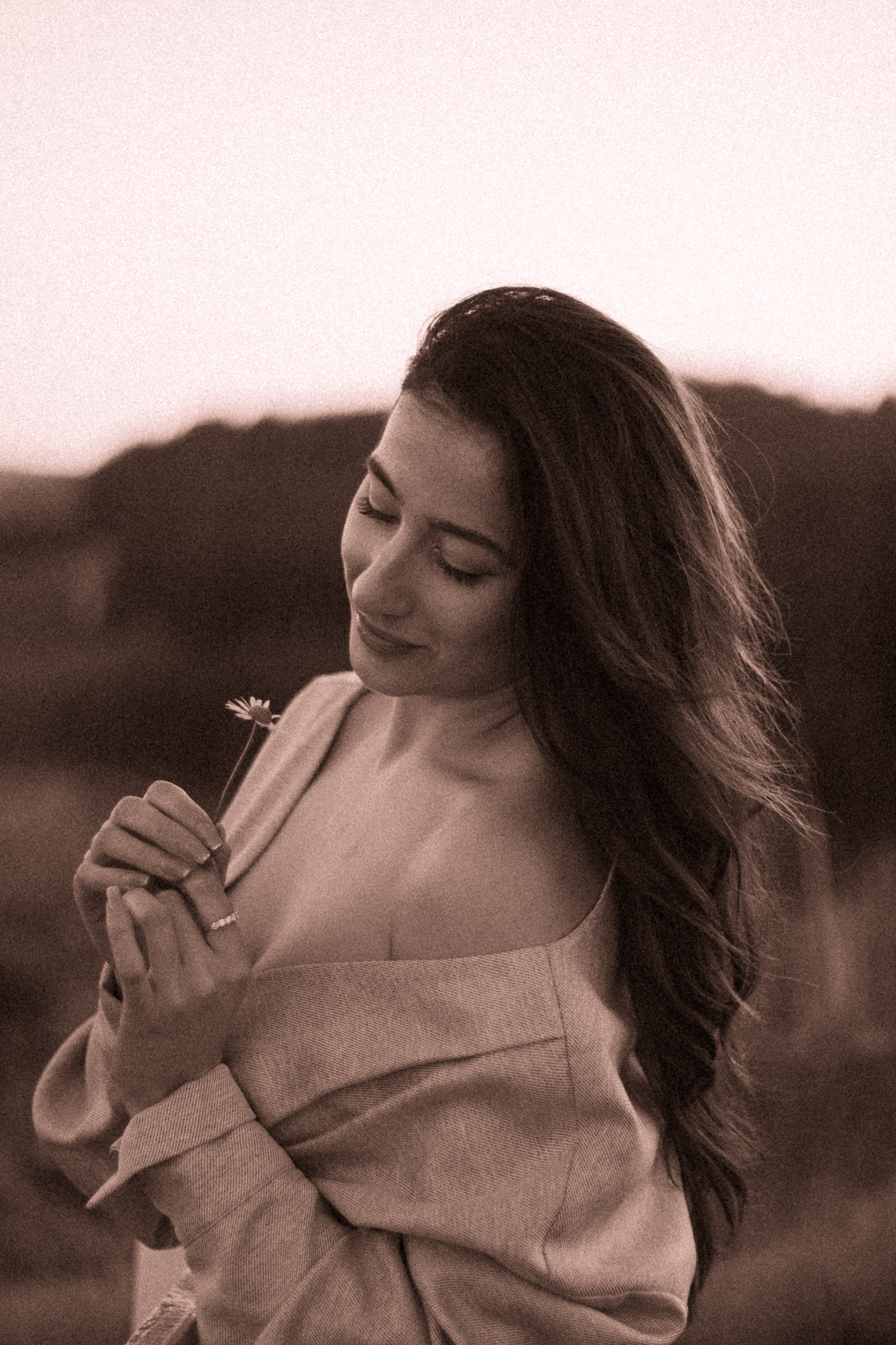 Kelly Brooke, founder of Reflector & Co., holding a flower outdoors.